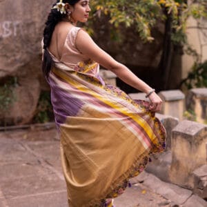 A classic kanjivaram saree with a monochromatic shades of lilac with a contrast multi colour horizontal stripe border