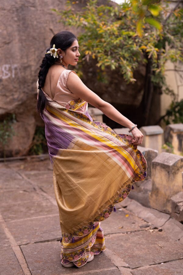 A classic kanjivaram saree with a monochromatic shades of lilac with a contrast multi colour horizontal stripe border