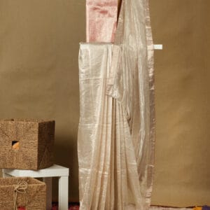 A handwoven zari tissue saree with contrast red brocade backing & blouse adding a minimalistic look.