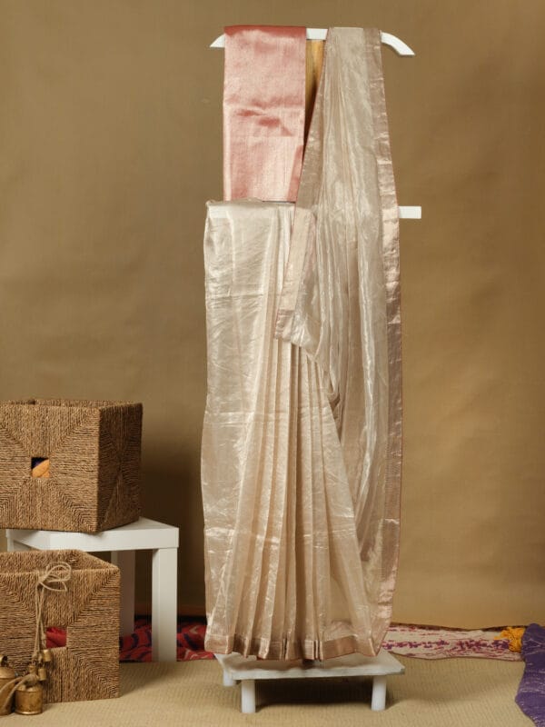 A handwoven zari tissue saree with contrast red brocade backing & blouse adding a minimalistic look.