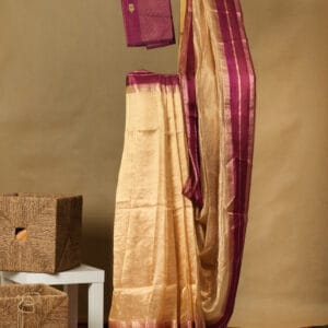 A gold tissue saree with a satin thread woven with zari border