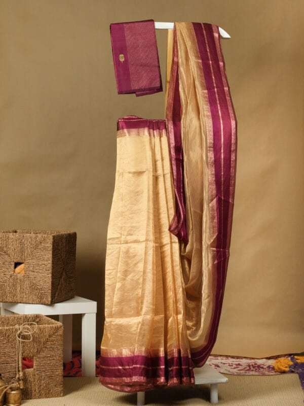 A gold tissue saree with a satin thread woven with zari border